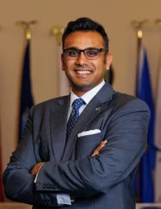 Pavan Parikh standing with his arms crossed wearing a suit