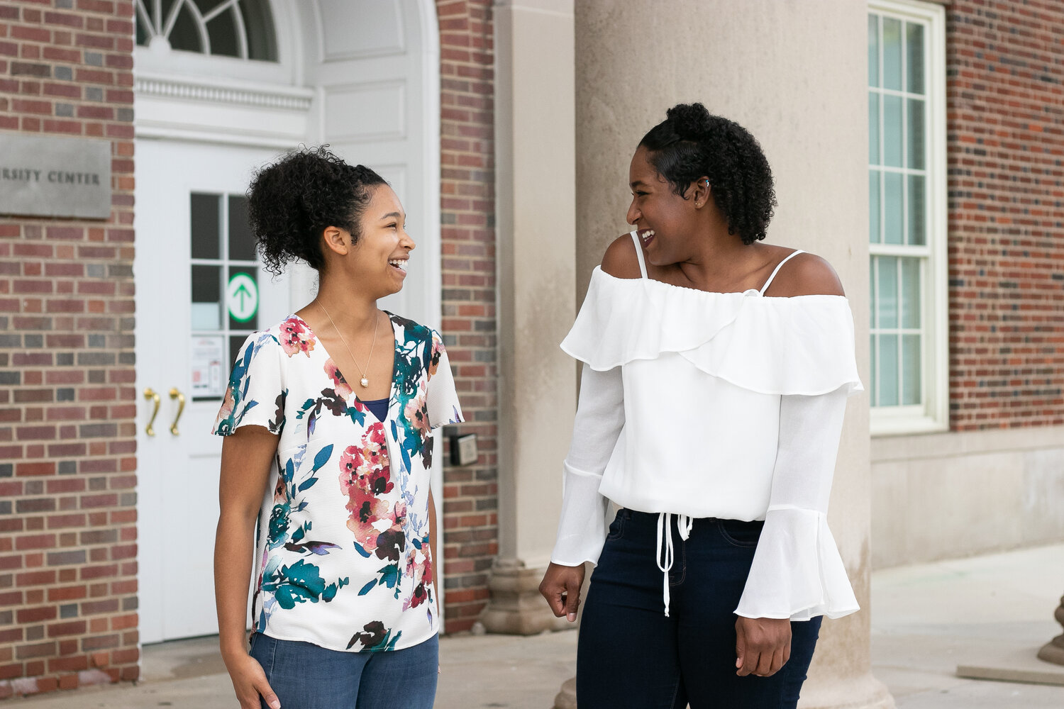 two Cincinnati women laughing together in front of building