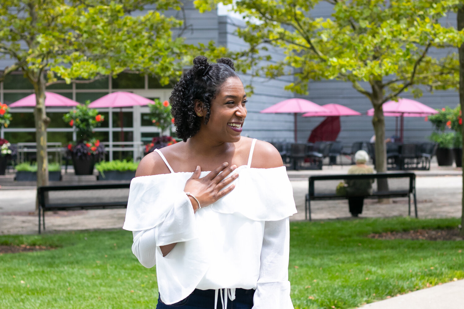 woman smiling with her hand on her white shirt